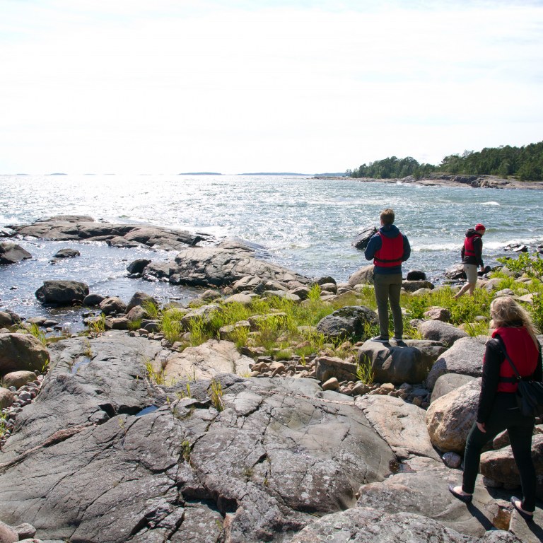 Three people walking at archipelago.