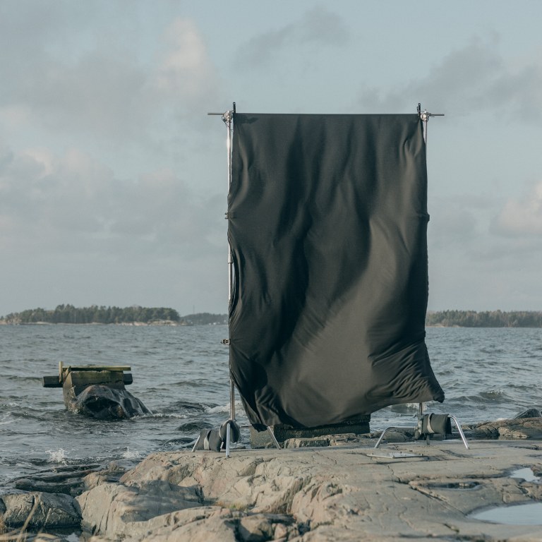 Black sheet fabric hung to dry by the sea