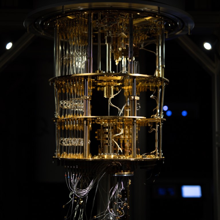 Gold-coloured quantum computer in darkly lit room.