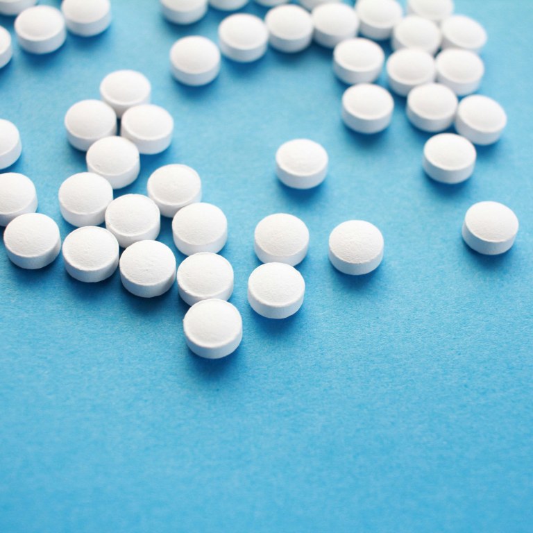 White round pills on a pale blue background