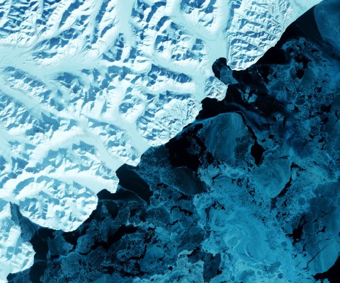 Cold blue satellite image of a glacier melting into water.