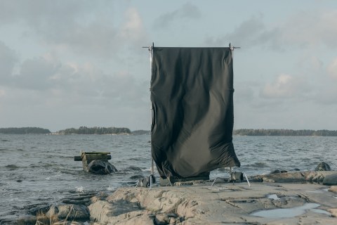 Black sheet fabric hung to dry by the sea