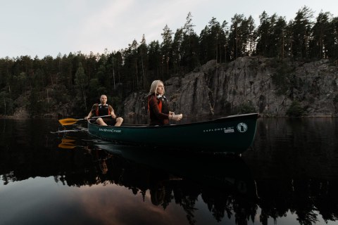 A man and a woman canoeing in the Nuuksio Hawk Lake