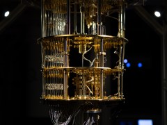 Gold-coloured quantum computer in darkly lit room.